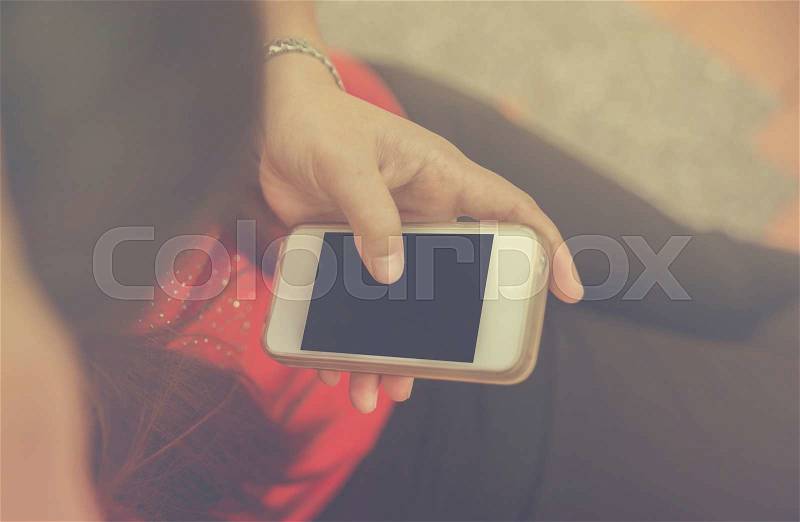 Women hand using smart phone. Vintage filter, stock photo