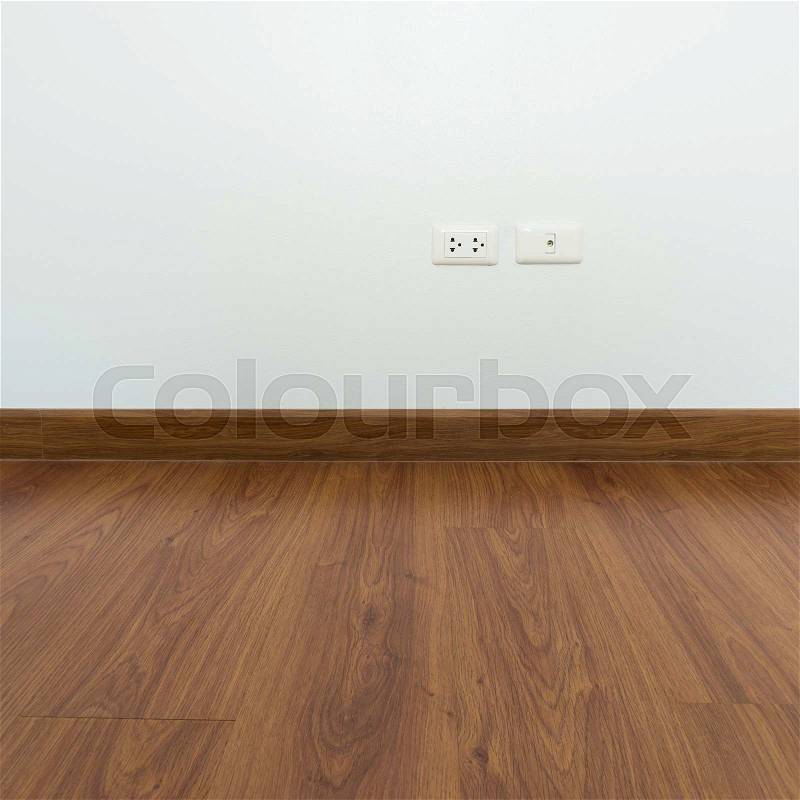 Empty room with brown wood laminate floor and white mortar wall background, stock photo