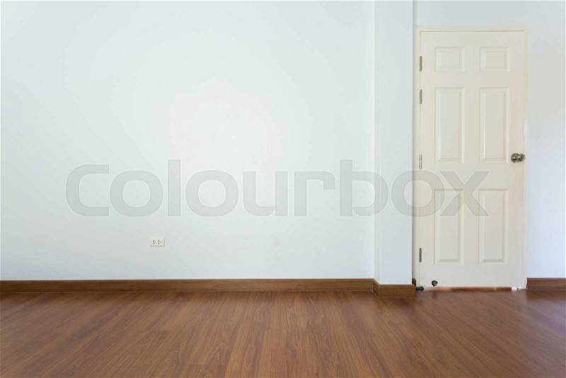 Empty room with brown wood laminate floor and white mortar wall background, stock photo