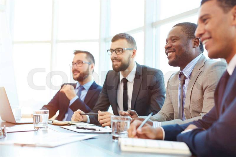 Happy businessmen sitting at conference, stock photo