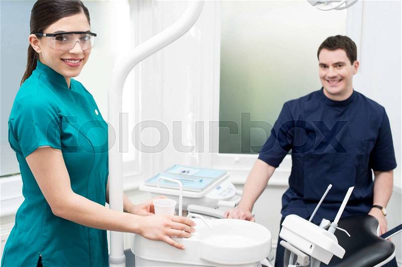 Orthodontist with female assistant in clinic, stock photo