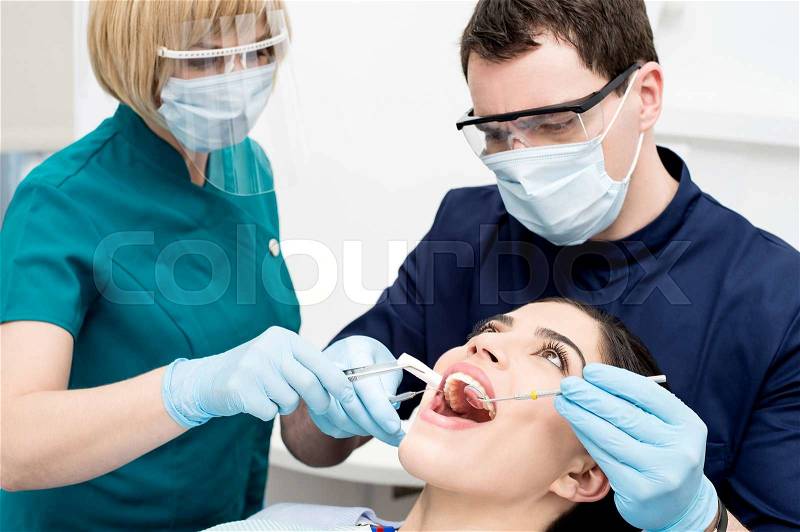 Dentist examining gums of patient, stock photo