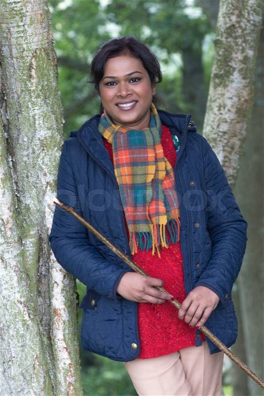 Happy woman smiling at the camera whilst out walking, stock photo