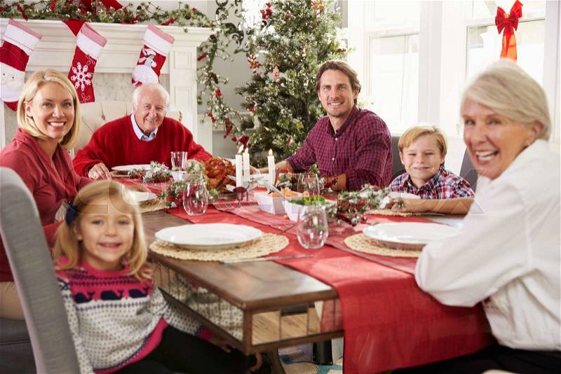 Family With Grandparents Enjoying Christmas Meal At Table, stock photo