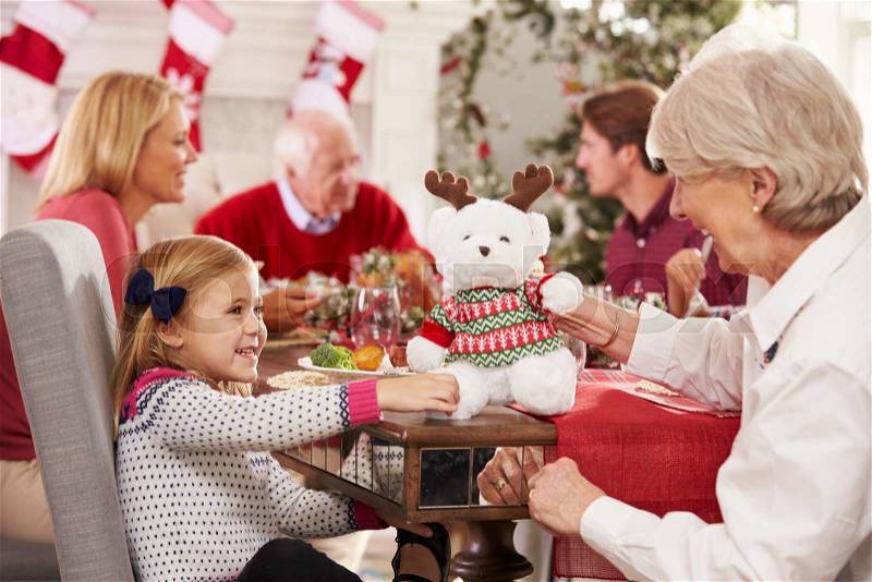 Granddaughter With Grandmother Enjoying Christmas Meal, stock photo