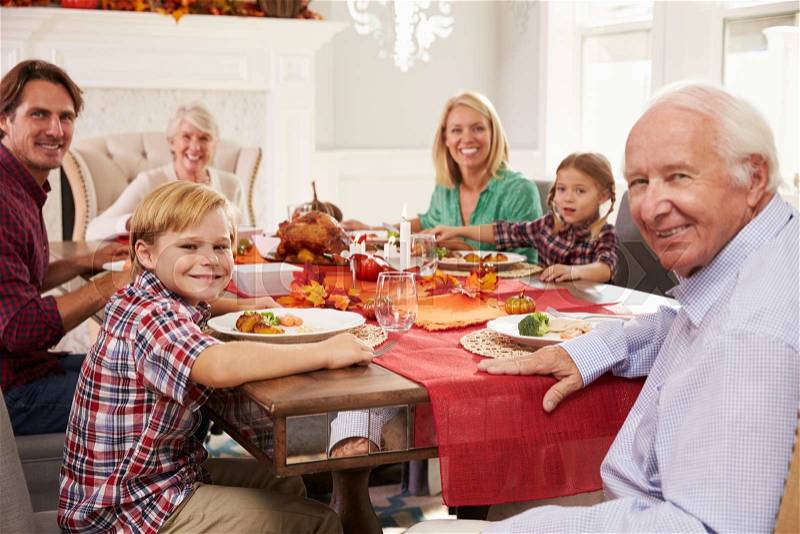 Family With Grandparents Enjoying Thanksgiving Meal At Table, stock photo