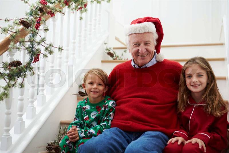 Grandfather With Grandchildren Sits On Stairs At Christmas, stock photo