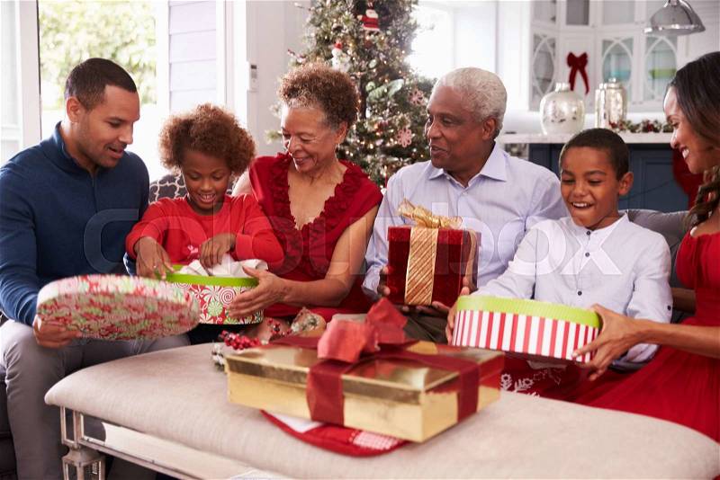 Family With Grandparents Opening Christmas Gifts, stock photo