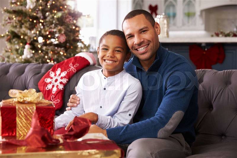 Father And Son Opening Christmas Presents At Home Together, stock photo