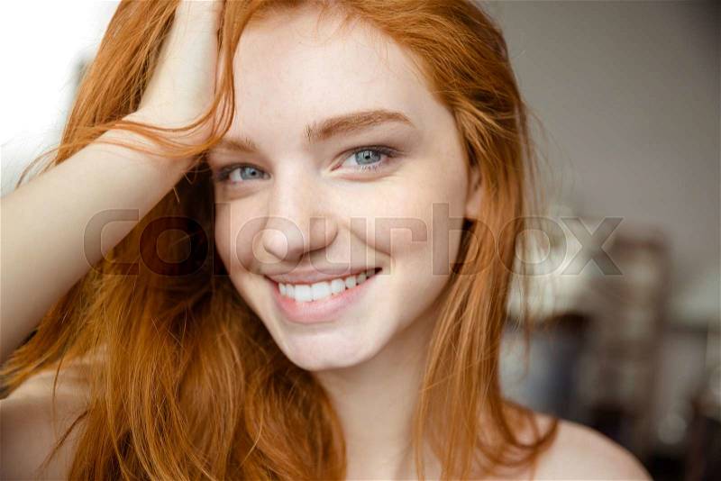 Closeup portrait of a happy redhead woman looking at camera, stock photo