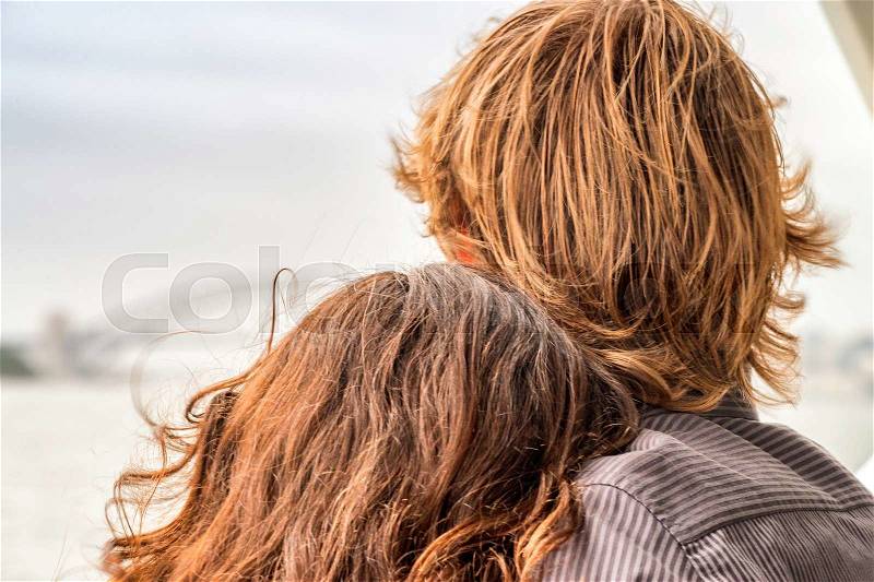 Embraced couple looking at city skyline, stock photo