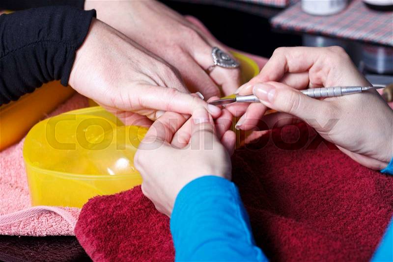 Manicure master at work. Close-up of beautician preparing customers fingers for manicure, stock photo