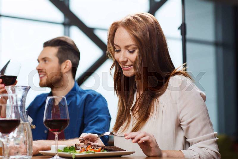 Leisure, food and drinks, people and holidays concept - happy couple having dinner at restaurant, stock photo