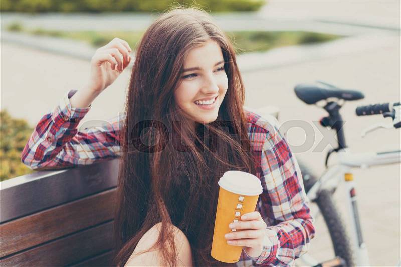 Young woman drinking coffee on a bicycle trip, stock photo