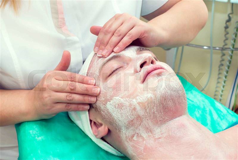Man in the process of facials in beauty salon, stock photo