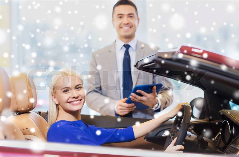 Auto business, car sale, technology and people concept - happy woman and car dealer with tablet pc computer in auto show or salon over snow effect, stock photo