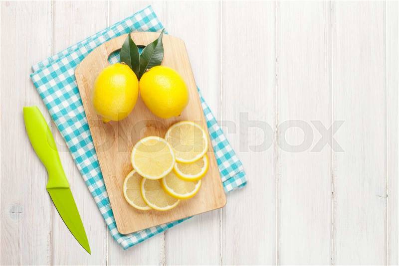 Sliced lemon on cutting board. Top view over wood table background with copy space, stock photo