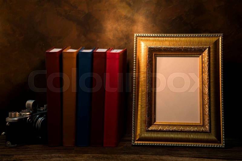 Still life of picture frame on table with vintage camera and diary book, stock photo