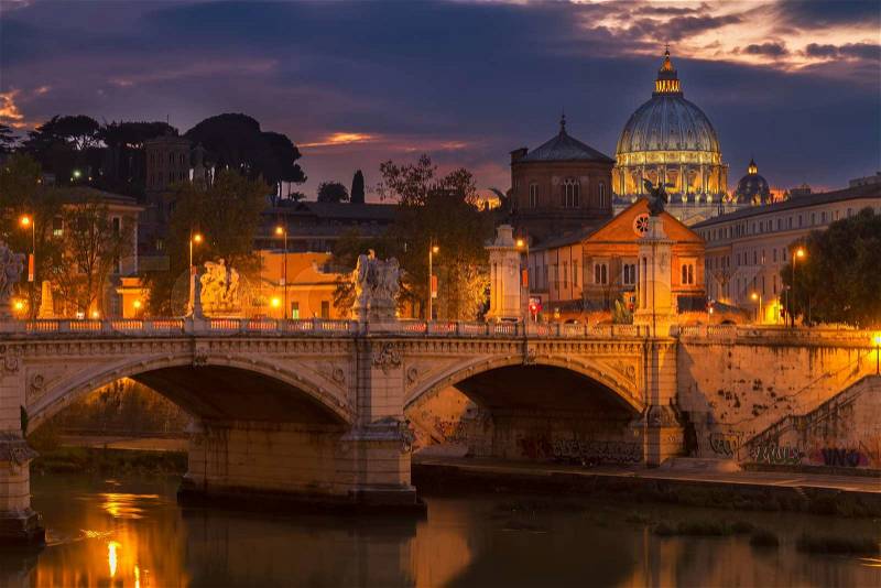 St. Peter\'s cathedral dome over bridge and river in Rome at night, Italy, stock photo