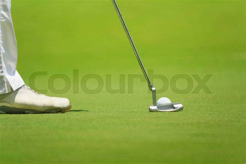 Golfer putting, selective focus on golf ball, stock photo