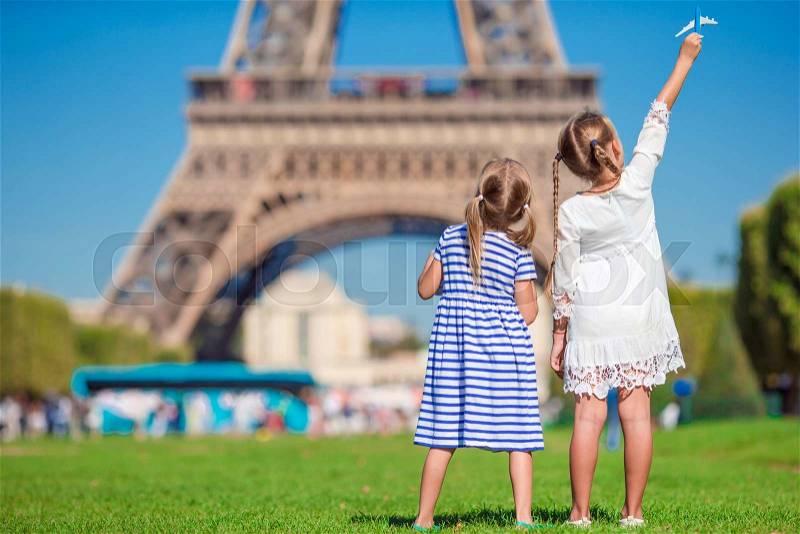 Adorable little girls in Paris background the Eiffel tower during summer vacation, stock photo
