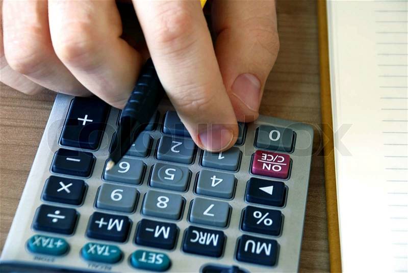 Man fingers over gray calculator buttons closeup, stock photo