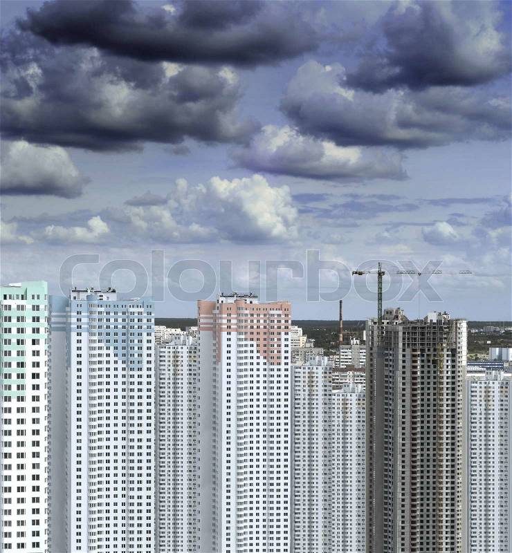 Darkness clouds gathering over building construction at summer, stock photo