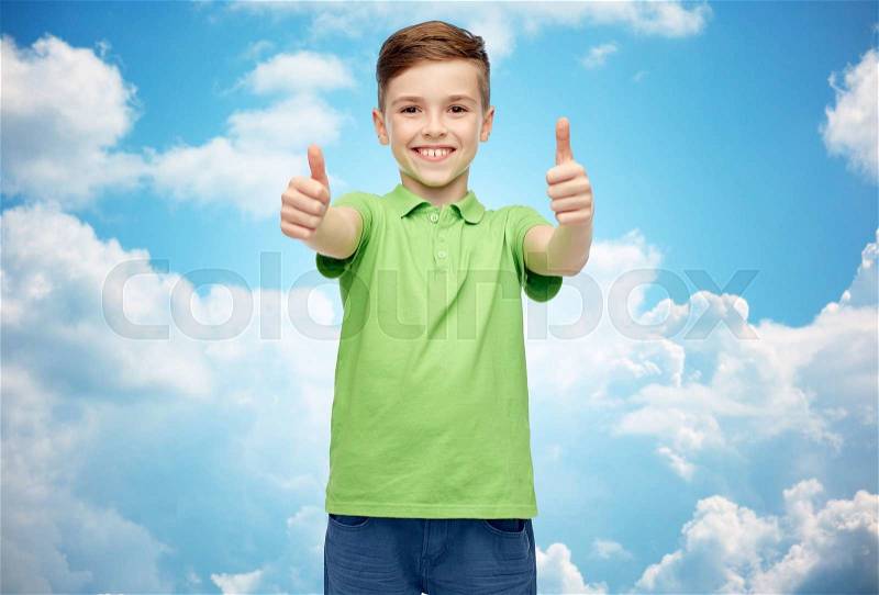 Gesture, childhood, fashion and people concept - happy smiling boy in green polo t-shirt showing thumbs up over blue sky and clouds background, stock photo