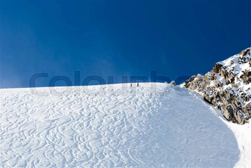 Off piste ski tracks on powder snow on a sunny winter day with blue sky, stock photo