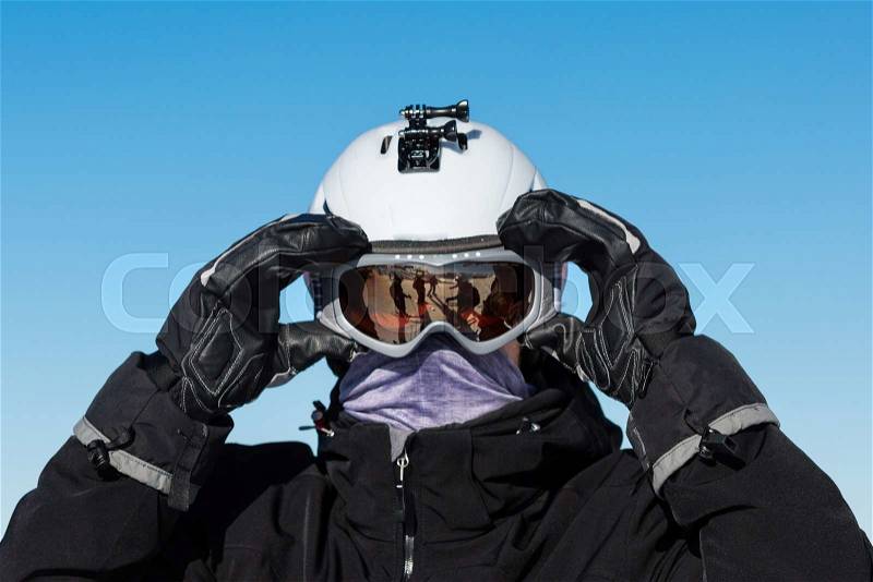 Close-up of male skier wearing ski goggles and ski helmet on a sunny day, stock photo