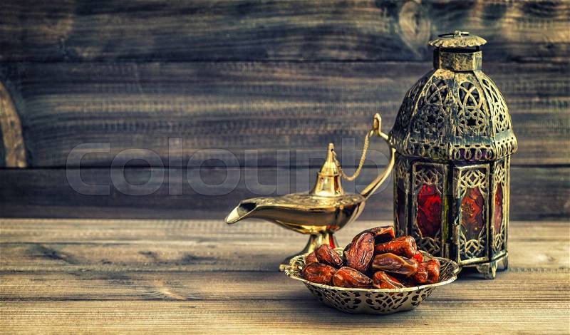 Ramadan lamp and dates on wooden background. Still life with oriental lantern. Vintage style toned picture, stock photo