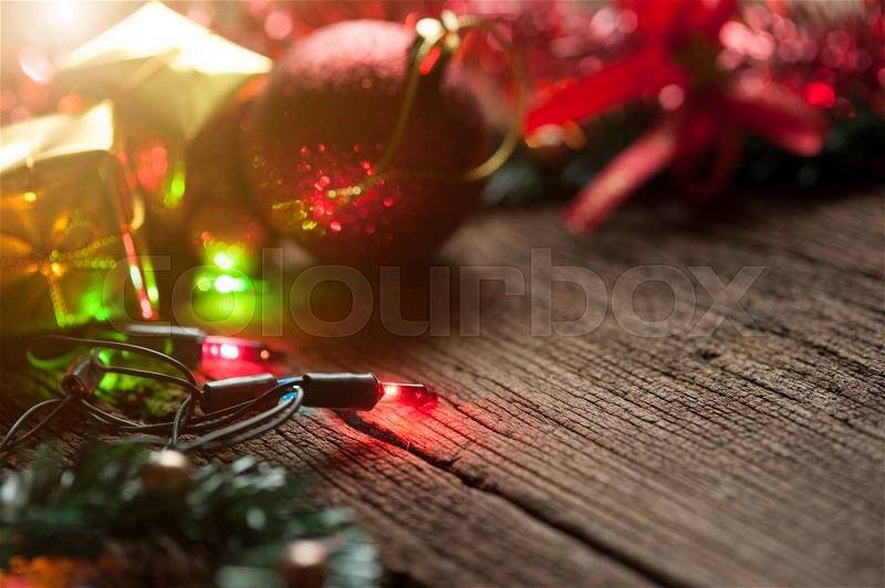 Christmas balls and colored Christmas lights on wooden table, selective focus, stock photo