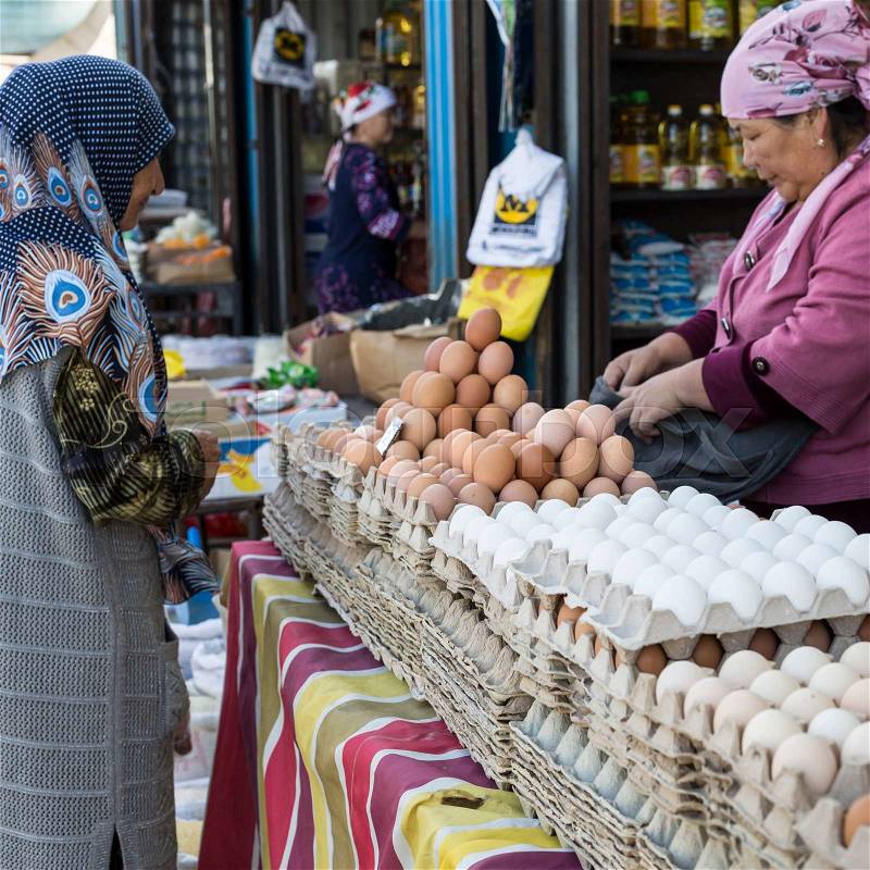 BISHKEK, KYRGYZSTAN - SEPTEMBER 27, 2015 : Woman selling eggs in local market, stock photo