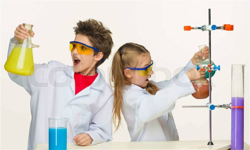 Two cute children at chemistry lesson making experiments on white background, stock photo