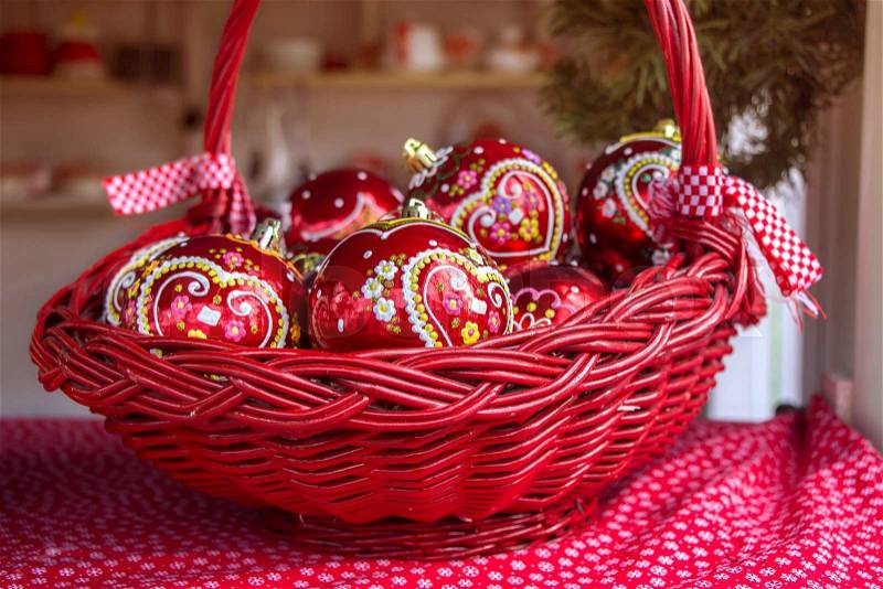 Red Christmas balls in basket, decorated with gingerbread heart, a traditional Croatian decorations, stock photo