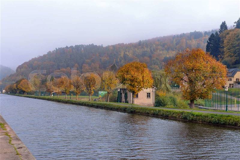 Houses near the river in the wood an autumn landscape, stock photo