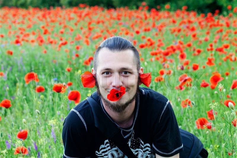 A funny guy and fields of poppies, stock photo