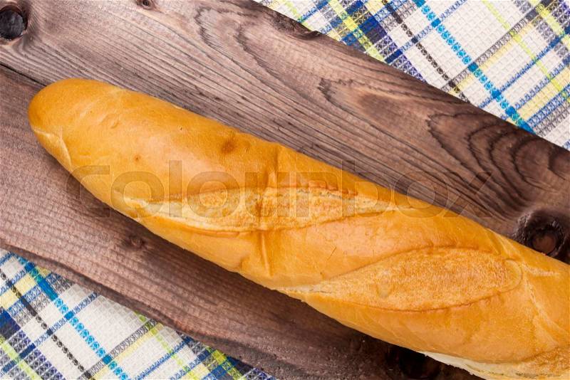 French baguette on a wooden background with a napkin, stock photo