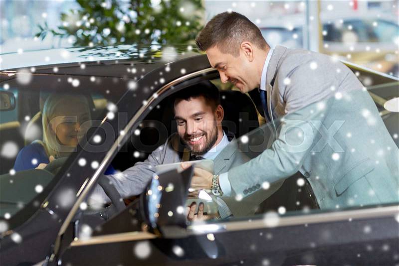 Auto business, car sale, technology and people concept - happy couple with car dealer with tablet pc computer in auto show or salon over snow effect, stock photo