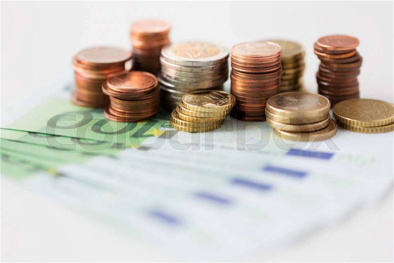 Business, finance, investment, saving and cash concept - close up of euro paper money and coins on table, stock photo