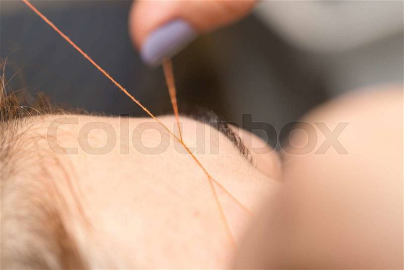 Grooming the eyebrows thread in a beauty salon. close, stock photo