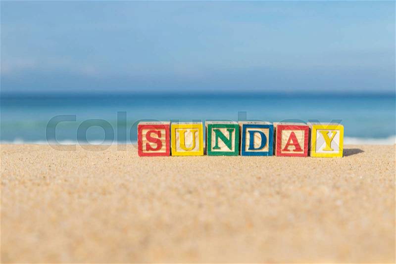 Word SUNDAY in colorful alphabet blocks on tropical beach, Phuket Thailand, stock photo