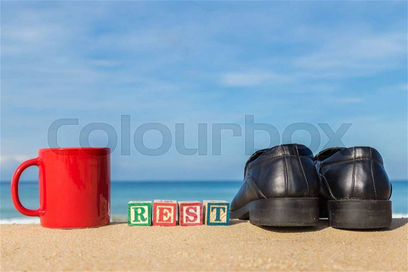 Word REST in colorful alphabet blocks and coffee cup on tropical beach, Phuket Thailand, stock photo