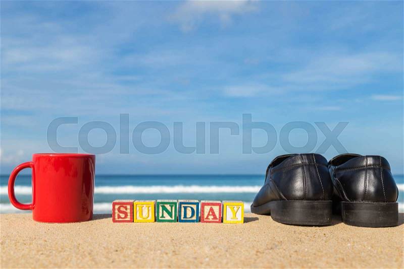 Word SUNDAY in colorful alphabet blocks and coffee cup on tropical beach, Phuket Thailand, stock photo
