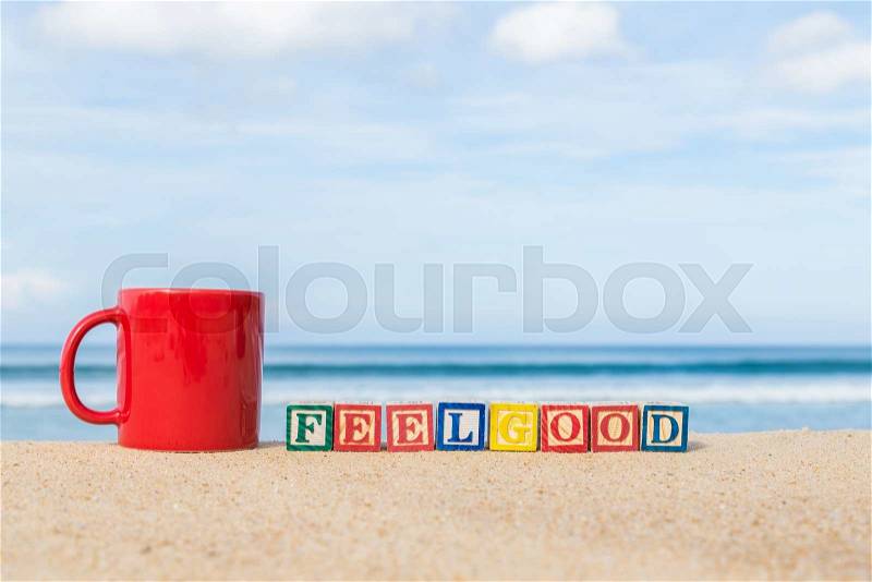 Word FEELGOOD in colorful alphabet blocks and coffee cup on tropical beach, Phuket Thailand, stock photo