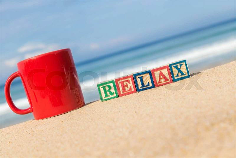 Word RELAX in colorful alphabet blocks and coffee cup on tropical beach, Phuket Thailand, stock photo
