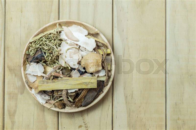 Mix of chinese herbal medicine in wooden dish on wood plank background, stock photo