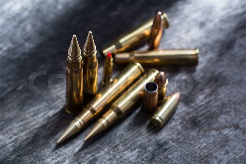 Composition of rifle and pistol copper cartridges stacked. Photographed in studio on a wooden textural background. , stock photo