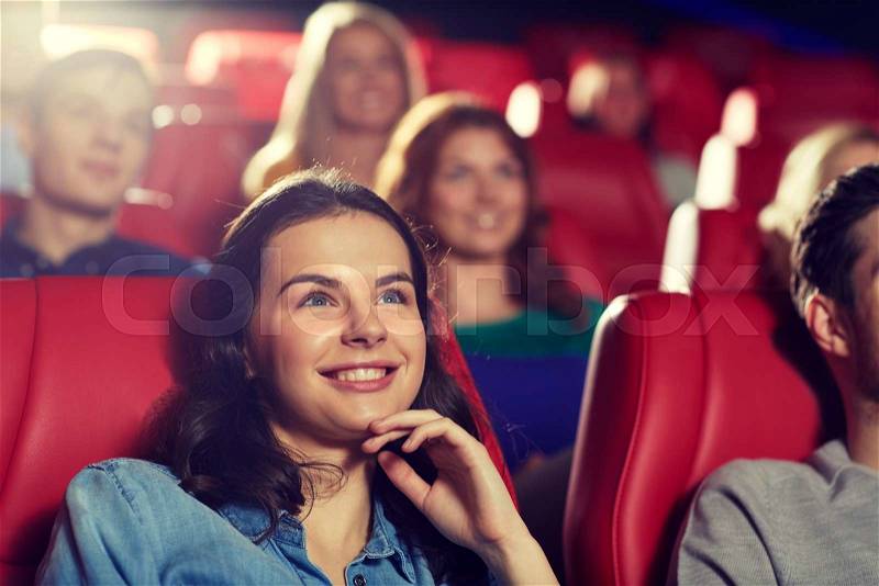 Cinema, entertainment and people concept - happy friends watching comedy movie in theater, stock photo