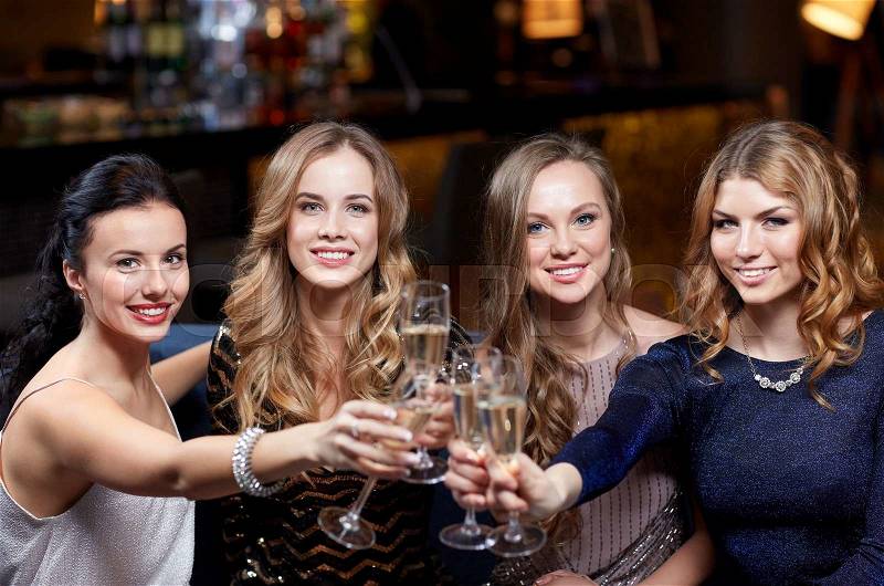 Celebration, friends, bachelorette party and holidays concept - happy women with champagne glasses at night club, stock photo